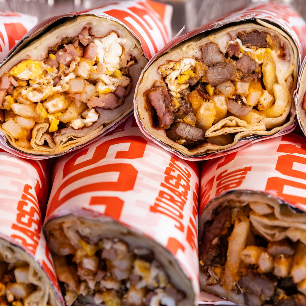 Stacked Jurassic Tacos breakfast burritos wrapped in branded paper